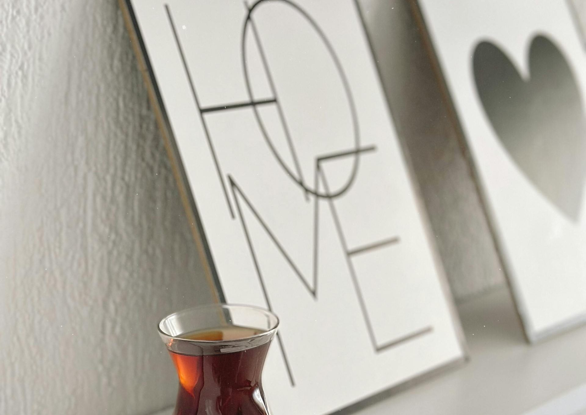 A Turkish tea glass sits elegantly on a minimalist shelf with modern art decor.
